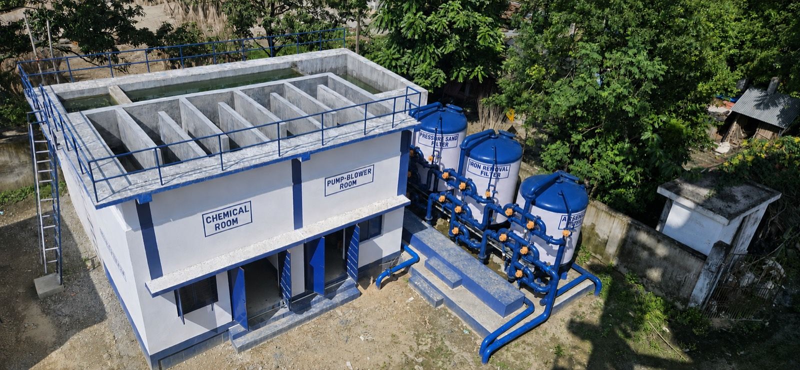Aerial view of the Dakshin Jhitkipota treatment plant in West Bengal: pressure sand, iron removal and arsenic removal vessels beside the chemical and pump rooms.